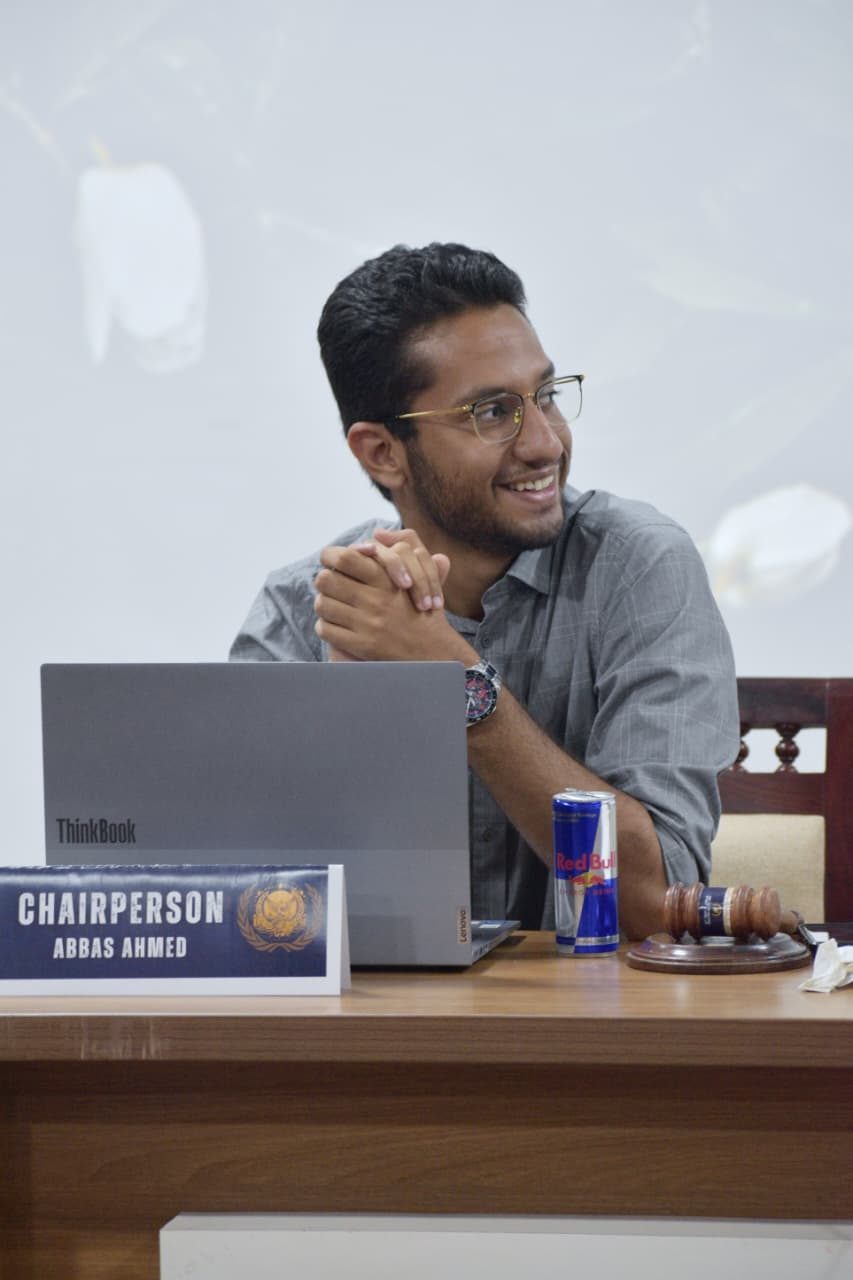 Abbas at a chairperson desk with a laptop and Red Bull