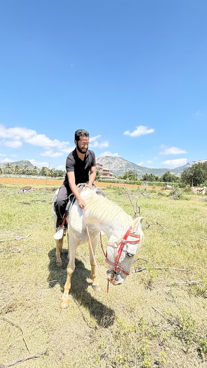 Abbas riding a white horse through a field