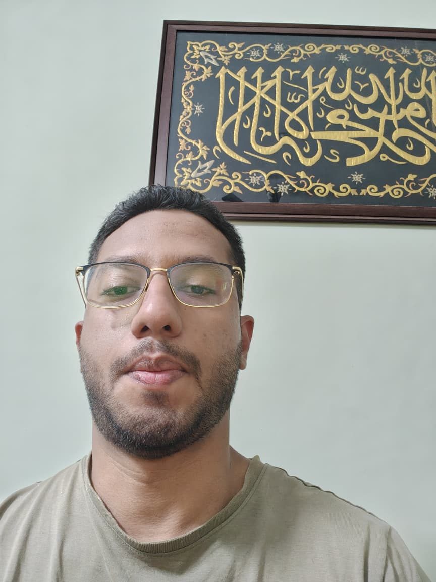 Abbas in front of a framed calligraphy