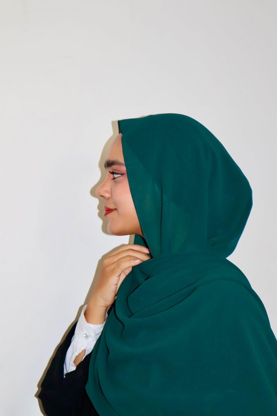 Arfa in a deep green hijab, in profile